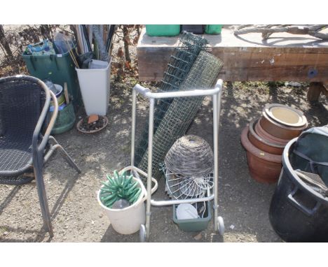 A quantity of garden netting, plant trough, hanging baskets, a bucket, a hose and a walking frame