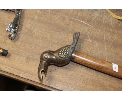 A walking stick with bird bottle opener handle