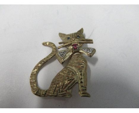 A 9 carat gold cat brooch, having sapphire eyes, with a diamond set bow tie centred with a ruby, 3.3cm long, 4.9g gross