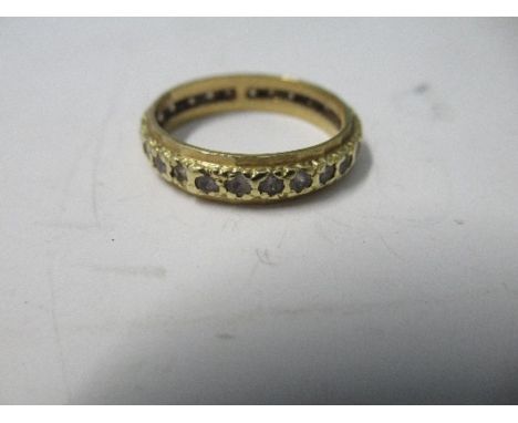 An 18 carat gold synthetic spinel set eternity ring, 3.1g gross