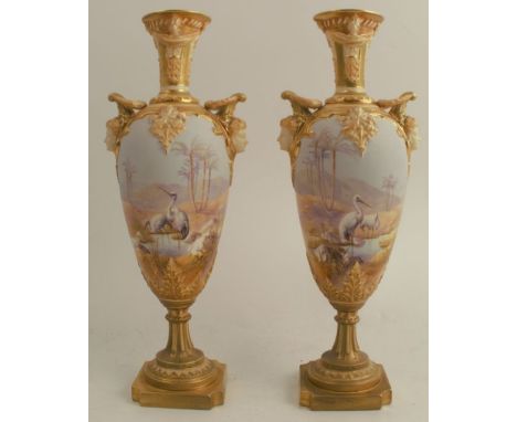 A pair of Royal Worcester vases, decorated with storks in an all around desert oasis landscape by Powell, shape number 1410, 