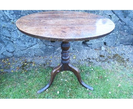 A 19th century circular oak occasional table, raised on a turned column terminating in a tripod base, diameter 28.5is x heigh