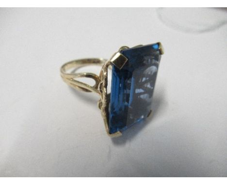 A large blue synthetic stone set ring, indistinct marks