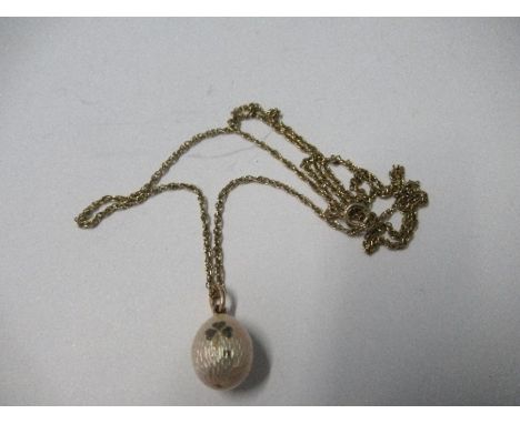 A Russian enamel egg pendant, stamped 56 to the jump ring, maker's mark A.W., decorated with clover, on a chain, chain marked
