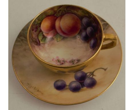 A Royal Worcester miniature cabinet cup and saucer, the interior of the cup and the saucer decorated with fruit to a mossy ba