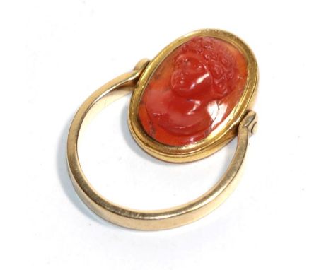 A carved carnelian cameo mounted swivel ring, carved in high relief depicting the bust of Bacchus, mounted to a swivel shank,