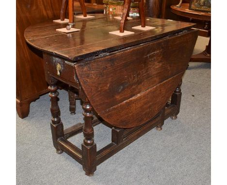 An early 19th century oak gate leg table, 132cm by 107cm by 71cm high