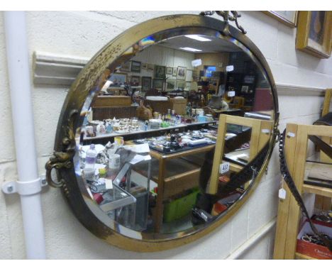 A large oval mirror in a brass surround 