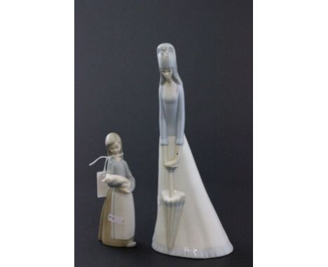 A Lladro figure of a girl holding a pig, along with a figure of a lady holding a umbrella 