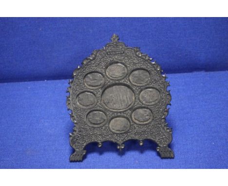 AN ANTIQUE ANGLO INDIAN CARVED HARD WOOD STAND FOR MINIATURES, WITH 9 OVAL APERTURES FITTED WITH BRASS EASEL STAND
