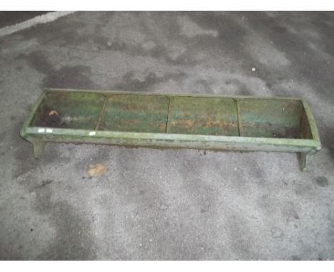 A LARGE CAST IRON CHICKEN FEEDER TROUGH