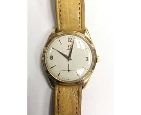 A vintage unisex Omega gold cased manual wind automatic wristwatch with raised batons and Arabic numerals at 12, 3 and 9 as w