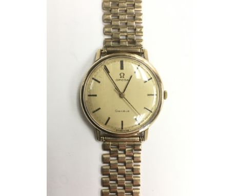 A gents vintage Omega 9ct gold automatic wristwatch with sepia dial and baton numerals, mounted on a 9ct gold strap, with int