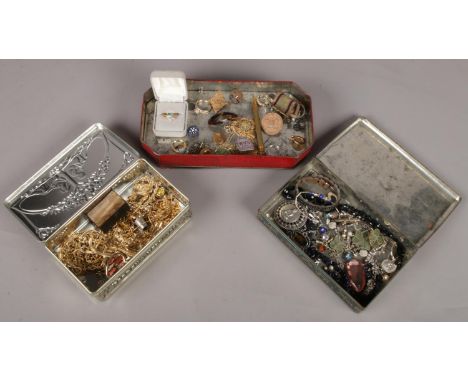 Three tins with contents of costume jewellery. Includes snuff box, gilt jewellery, vintage examples etc.  