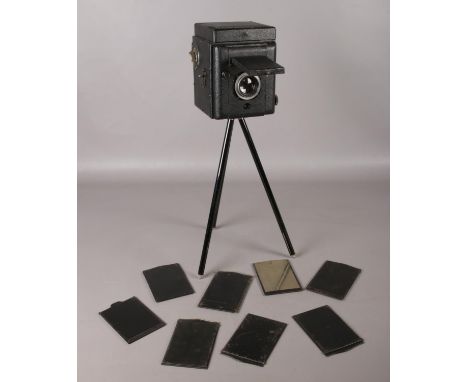 A vintage Reflex camera on tripod with extra plates.  