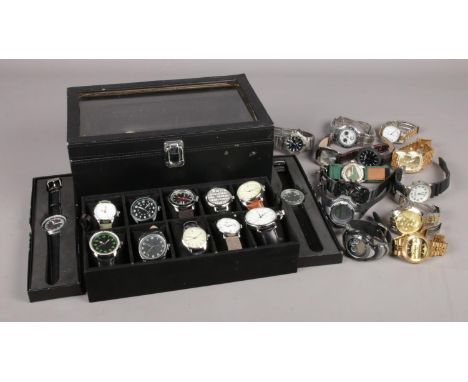 A large collection of quartz wristwatches, to include twenty contained within a display case. Examples from Sekonda, Timex an