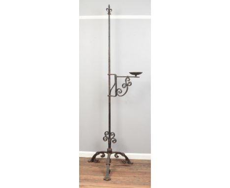 A large wrought iron candlestick, with branched arm and scrolled tripod base. Height: 224cm high.  
