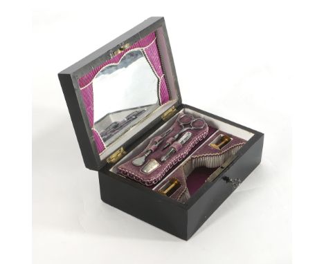 A travelling compactum in an ebony box and an enamel plaque and brass stringing.
