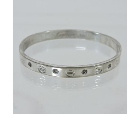 A silver and diamond set hinged bangle, marked Cartier
