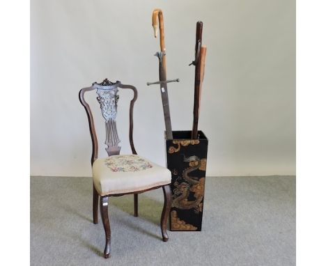 A painted wooden stick stand, 61cm tall, containing a decorative sword and three walking sticks, together with an Edwardian b