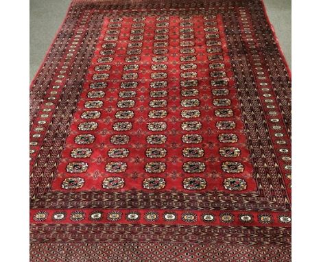 A Bokhara carpet, with all over medallions, on a red ground, 275 x 180cm