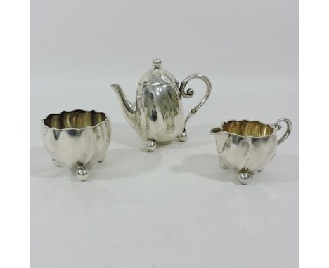 A continental silver three piece tea service, comprising of teapot, 12cm tall, sugar and cream jug