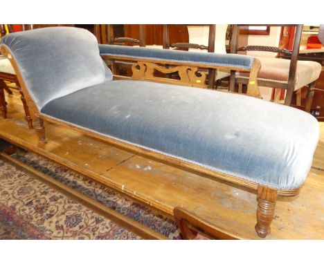 A late Victorian oak framed day bed, having blue fabric upholstery, on ring-turned supports, length 170cm