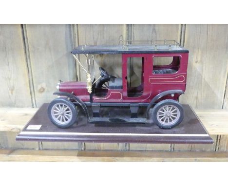 A large scale tinplate pre-war car, on plinth