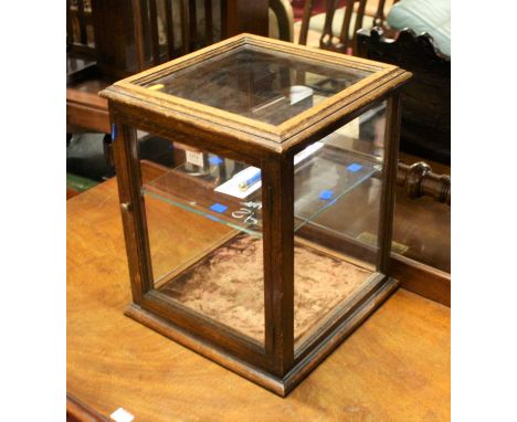 An early 20th century oak table-top glazed display case, having single door and single glass interior shelf, h.42.5cm, w.35cm