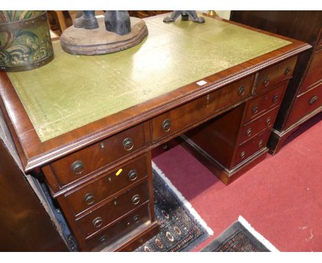 An early 20th century mahogany and gilt tooled green leather inset twin pedestal writing desk, having typical arrangement of 