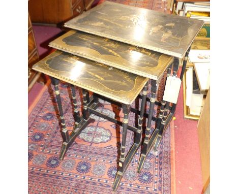 An early 20th century chinoiserie black lacquered and gilt decorated nest of three occasional tables, each depicting a figure