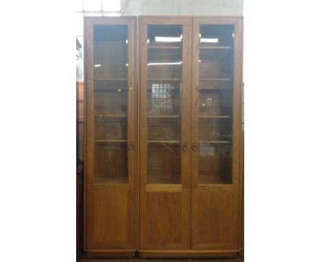 A multi-piece 'Ercol' display unit in four pieces. Single display cabinet: 214cm x 47cm x 31cm, double display cabinet: 214cm