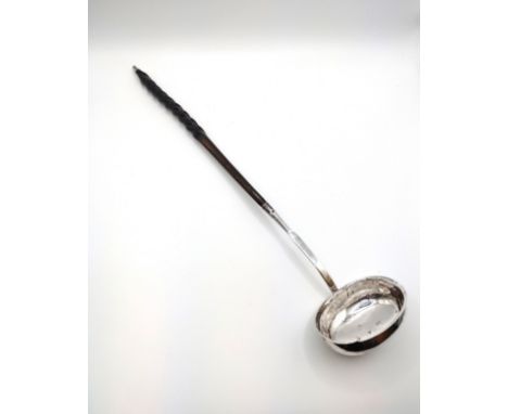 A George III silver whalebone handled punch ladle, hallmarked to interior of bowl, approximately 32 cm long. 