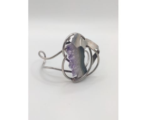 A white metal bangle set with amethyst geode. 