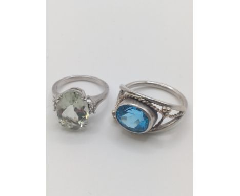 A silver and green amethyst (prasiolite) dress ring, size L 1/2, together with a white metal and blue topaz dress ring, with 