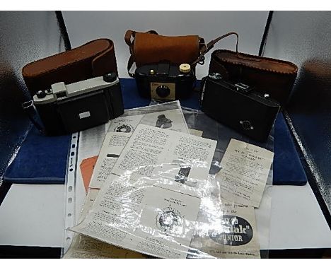 3 vintage Kodak cameras: Kodak Brownie 127 in case, Kodak Anastigmat kodon shutter in stitched leather case and Kodak kodette