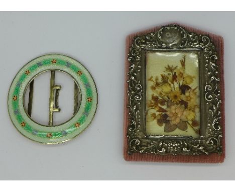 A silver and enamelled buckle and a silver picture frame, enamel a/f, diameter of buckle 64mm