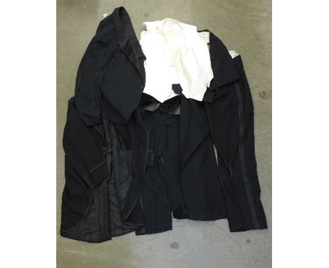 A collection of men's vintage clothes including an evening suit, waistcoats and trousers
