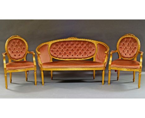 A French giltwood salon suite, early 20th century, with salmon pink button back upholstery, to comprise a pair of sofas and f