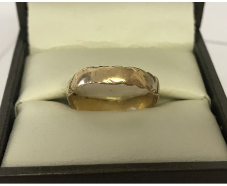 A 9ct gold vintage wedding band. Scalloped edge design with worn pattern to outside. Ring size O. Total weight approx.1g.