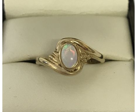 A 9ct gold dress ring set with an oval cut cabochon opal. Twist style decorative mount. Size N. Total weight approx. 2.2g.