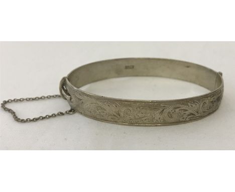 A vintage oval shaped half engraved silver bangle complete with safety chain. Hallmarked Birmingham 1957. Total weight approx