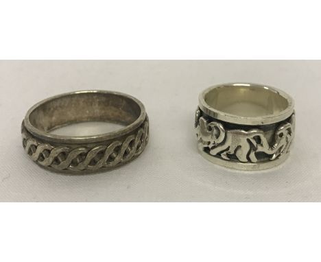 2 silver spinner band rings. One with elephant decoration the other with a Celtic design. Sizes K½ and Z. Total weight approx