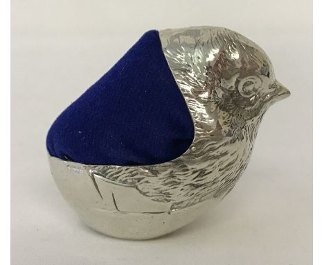 A 925 silver pin cushion in the shape of a chick hatching from an egg. With blue velvet cushion. Hallmarked for Birmingham. A