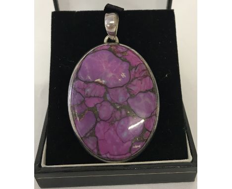 A large oval silver pendant set with purple coloured natural stone. Makers initials and 925 mark to bale. Approx. 6cm x 4cm i