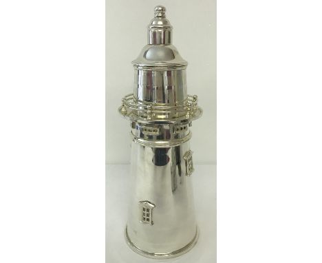 A large silver plated cocktail shaker in the shape of a lighthouse.  Approx. 35cm tall.