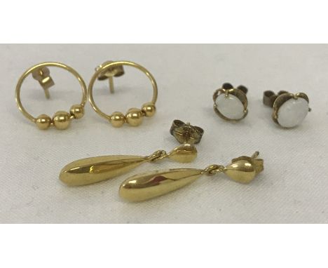 3 pairs of 9ct gold earrings. A pair of oval gold drops, together with a pair of opal set studs and a pair of circular studs 