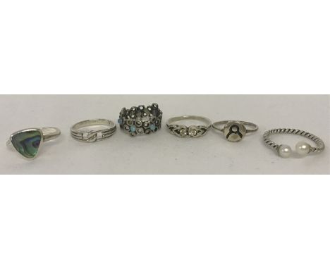 6 silver and white metal dress rings. To include abalone shell , pearl and opal set.  Sizes range from H to O.