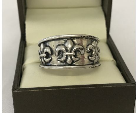 A men's silver band style ring with fleur de lis decoration. Size U½.  Total weight approx. 11g.
