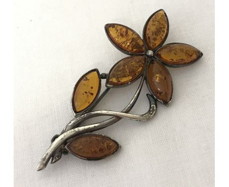 An amber set silver flower brooch. Petals &amp; leaves set with marquise cut amber. Marked 925 to reverse. 